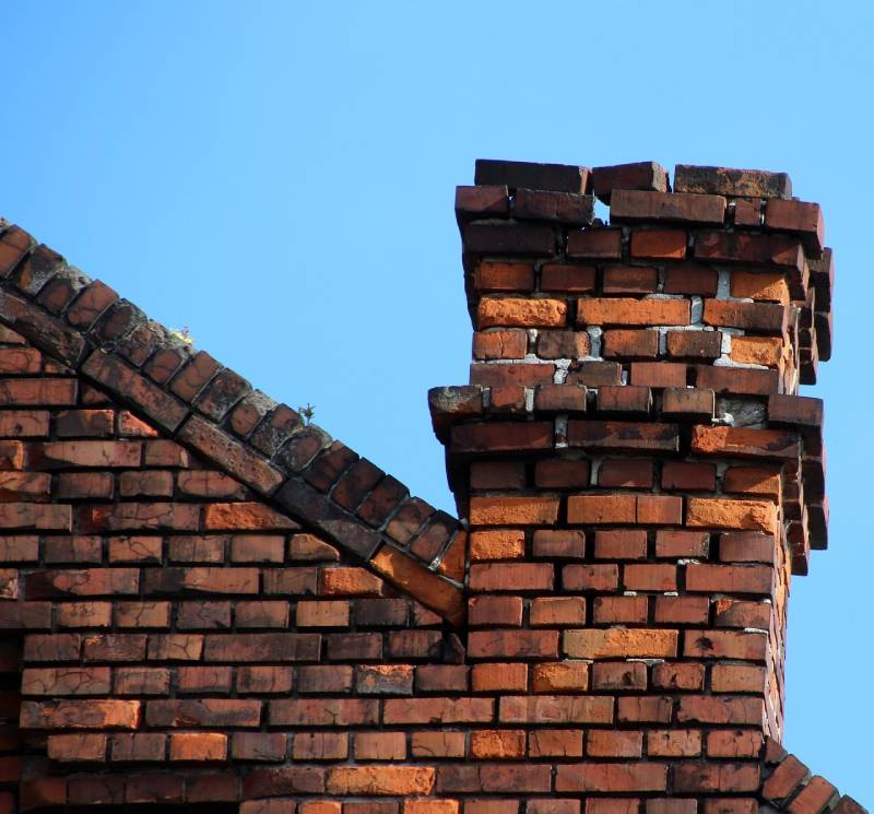 Damaged chimney on an Hialeah home showing cracks and missing mortar